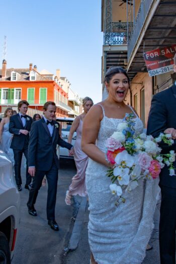 A joyful couple on their wedding day in New Orleans, surrounded by friends and family