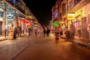 Vibrant scene of Bourbon Street in New Orleans, showcasing lively atmosphere and historic architecture