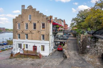 A scenic view of Factors Walk in Savannah, GA, showcasing historic buildings and cobblestone streets