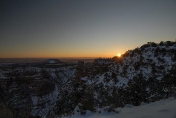 A panoramic sunrise view of the Grand Canyon showcasing its vast landscape and colorful rock formations