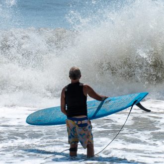 Surfer scoping out the waves in Virginia Beach, capturing the thrill of surfing in a vibrant ocean setting