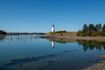 Mulholland Point Lighthouse on Campobello Island, New Brunswick, surrounded by autumn foliage