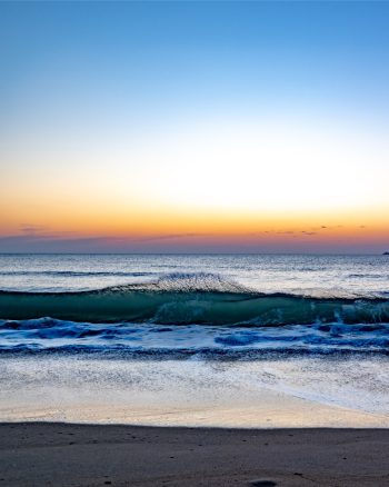Sunrise over Virginia Beach, casting warm hues across the sky and reflecting on the calm ocean waters
